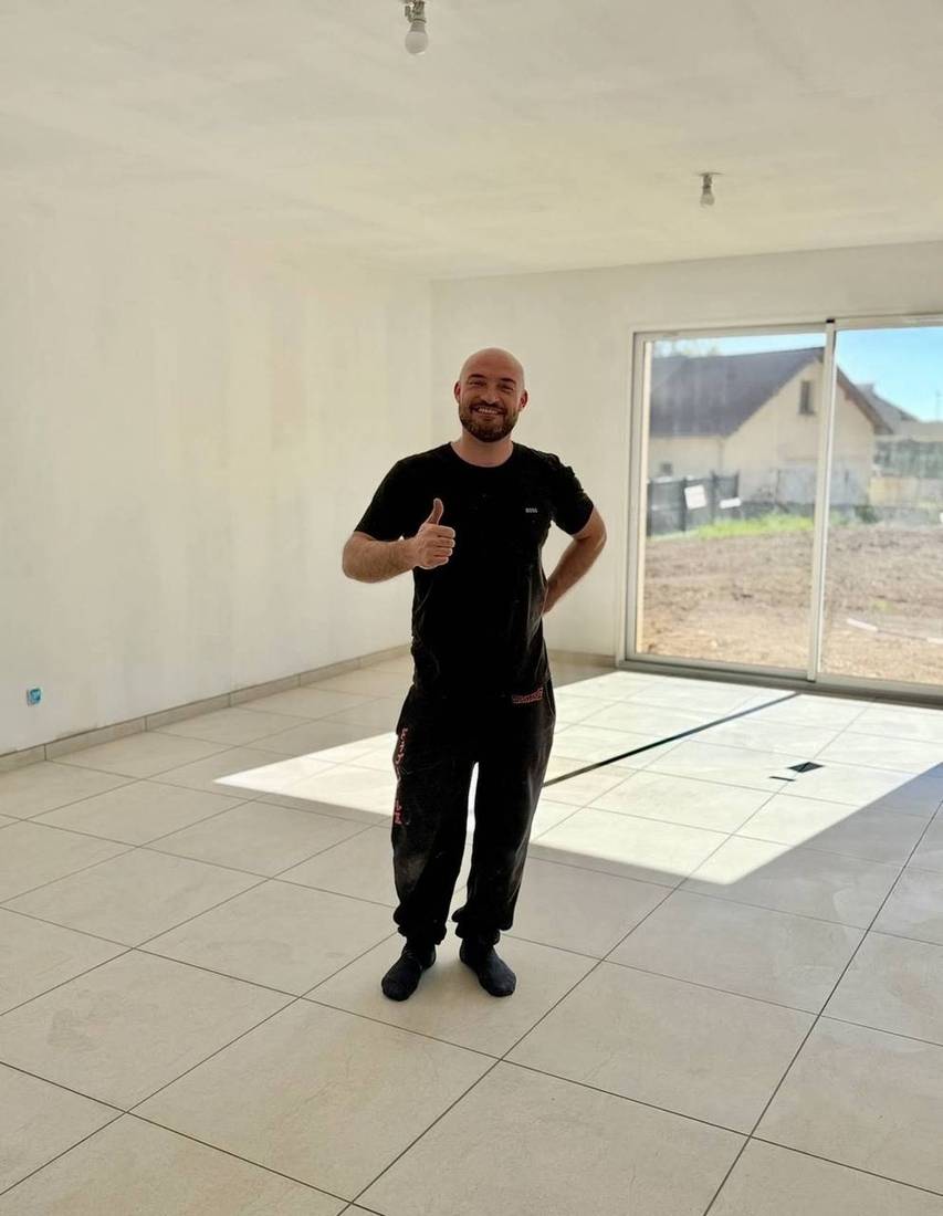 Client satisfait à la livraison du chantier : séjour, carrelage clair