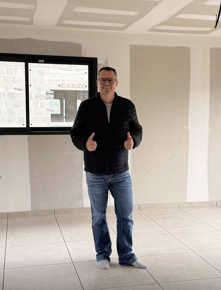 Client satisfait à la livraison du chantier : sol carrelé, maison neuve