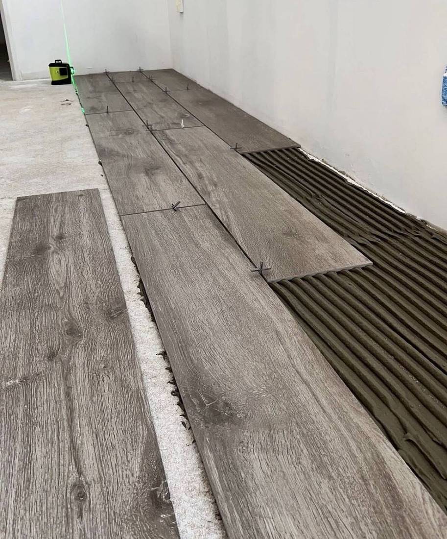 Pose collée de carrelage effet bois, double encollage et repère laser