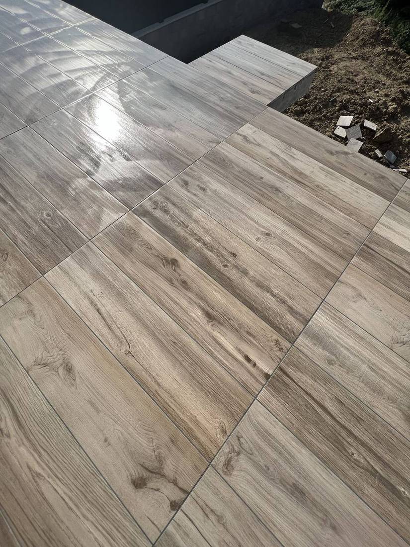 Détail d’une terrasse en carrelage effet bois aux joints réguliers